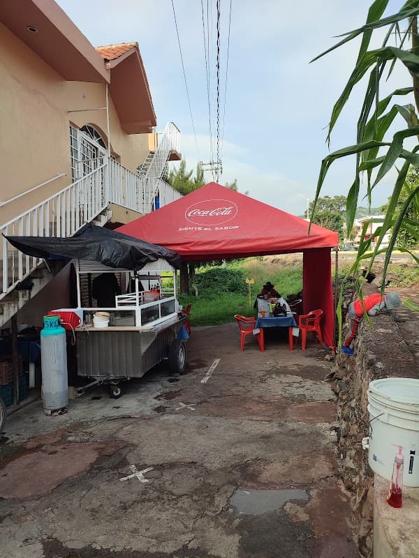 Exterior de TimeOut Bar con luces de neón y barra llena de copas, vista del letrero al anochecer
