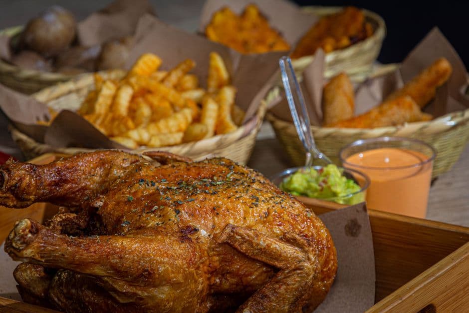 Delicious roasted chicken served with fries and dips, perfect for a hearty meal.
