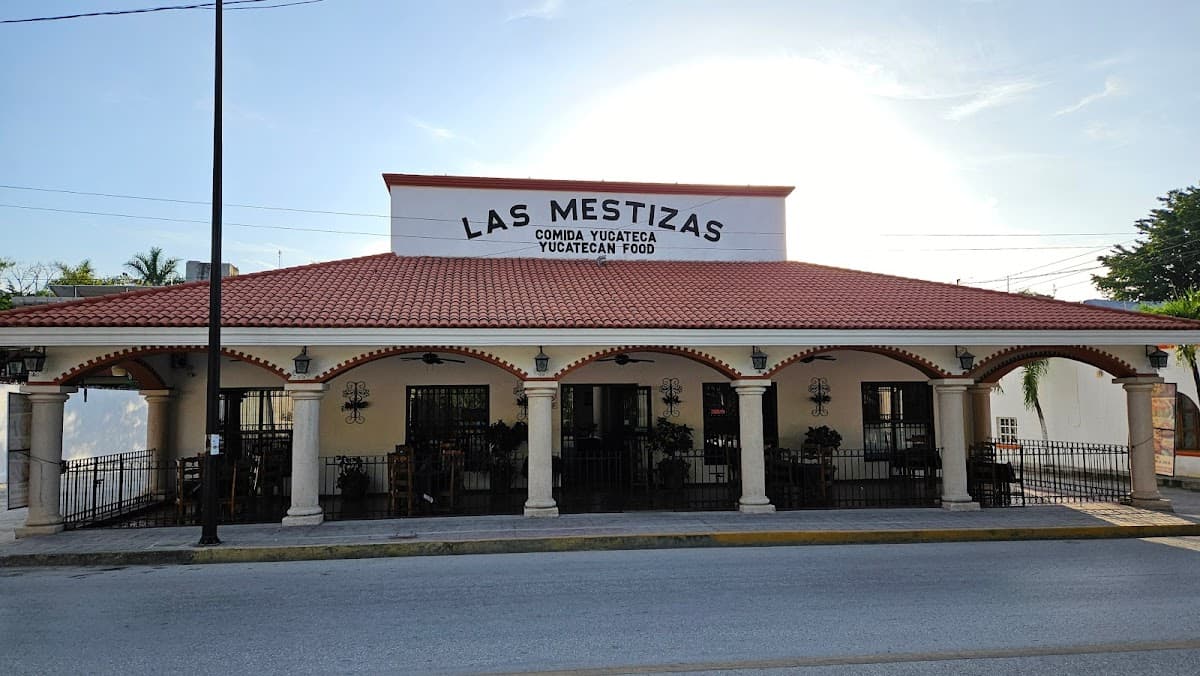 Luna Café exterior con mesas al aire libre, mostrando una taza de café y un crepe de frutas en primer plano