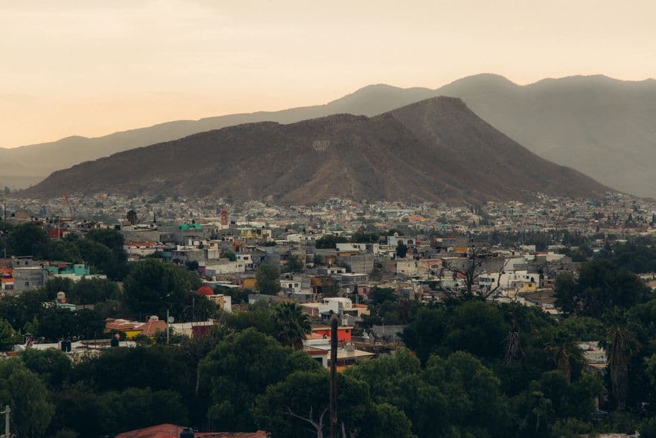 Scenic aerial view of a Mexican town with mountains at twilight.
