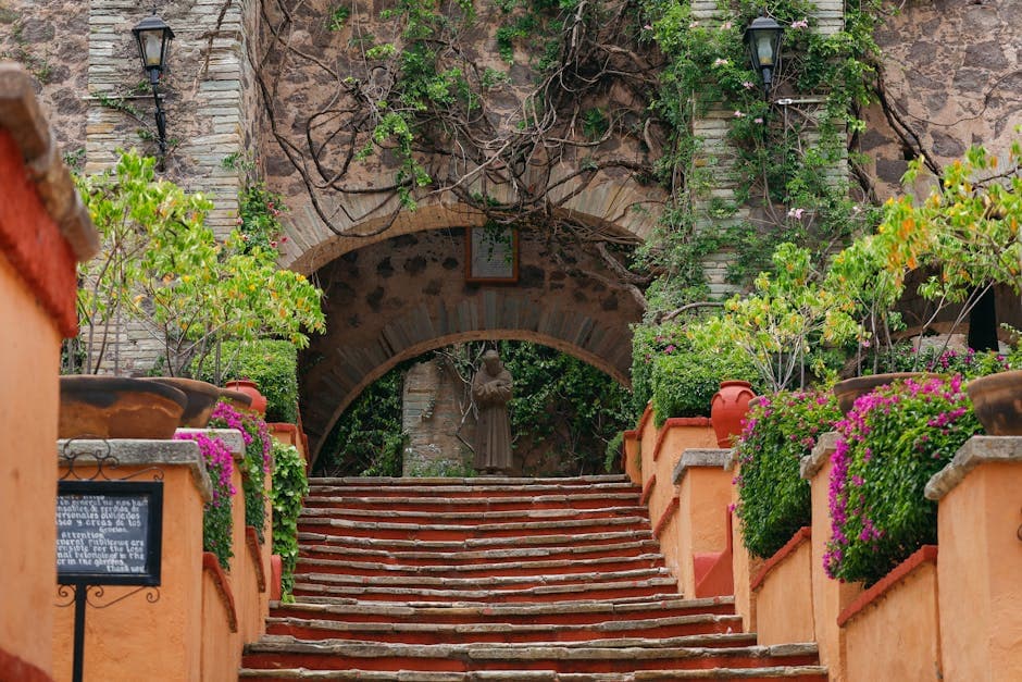 Elegant stone archway with vibrant plants at a Guanajuato hacienda.