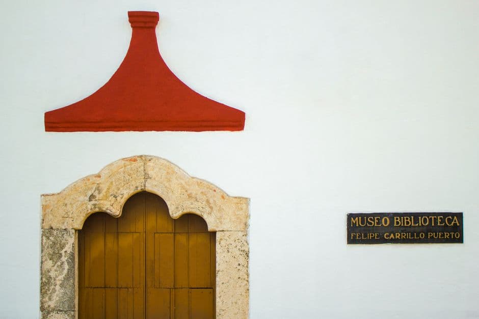 Details of exterior of aged building of museum with wooden door decorated with carved stone arch located in Mexico