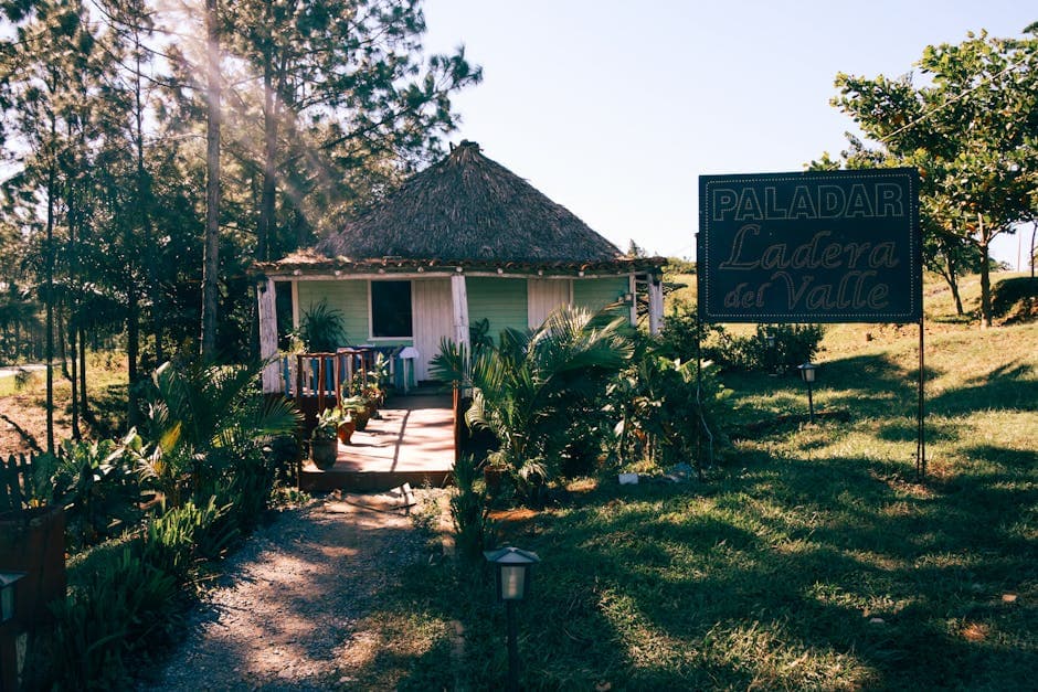A picturesque rural restaurant, 'Paladar Ladera del Valle', with a thatched roof and lush surroundings.
