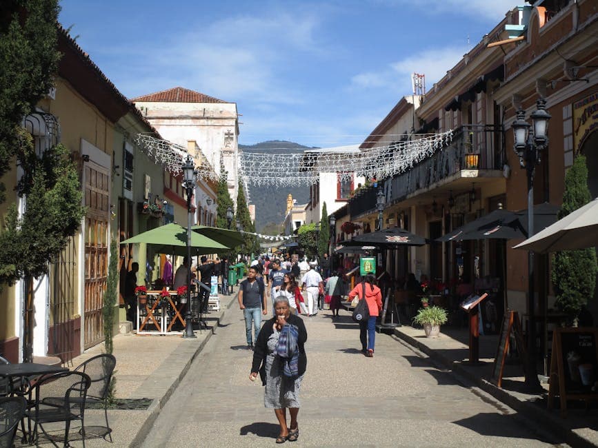 Bustling street in San Cristóbal de las Casas, capturing vibrant local life under a sunny sky.