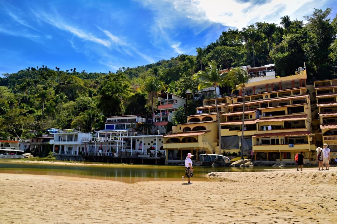 Beachfront buildings and lush green hills meet.