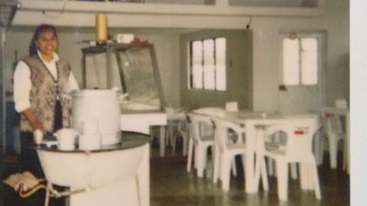 Interior de Café 406 con mesas de madera, clientes jugando a juegos de mesa y una taza de frapes sobre la barra