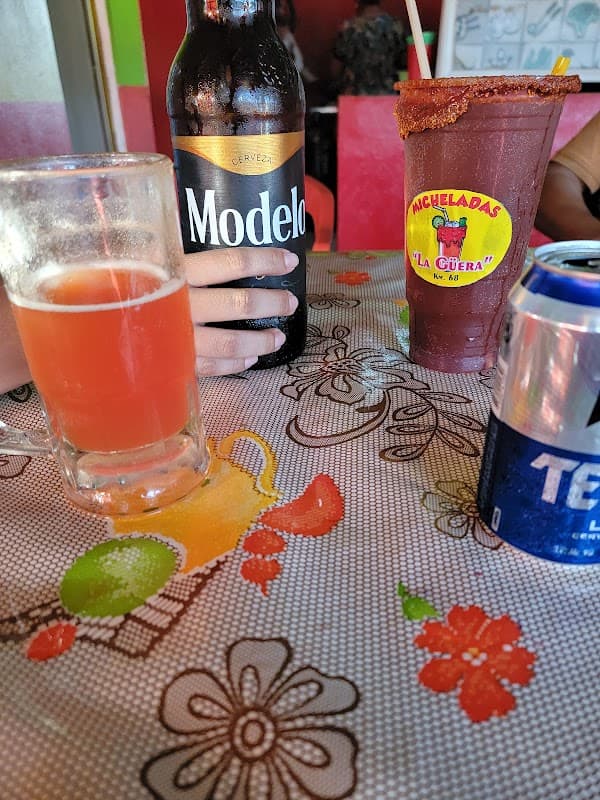 Comedor La Güera — fachada iluminada de noche y una bandeja de empanadas recién fritas sobre la mesa