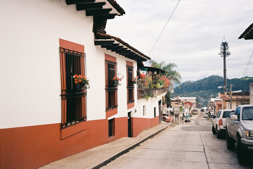 A street lined with white and red buildings and cars.