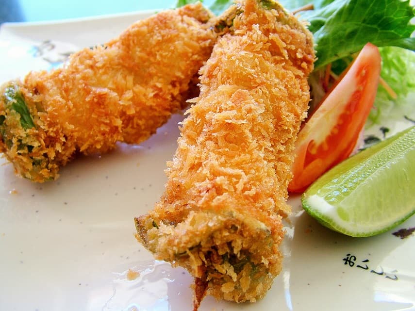 Ken Gourmet Japones con su mostrador de sushi iluminado, platos de tempura y clientes disfrutando la cena