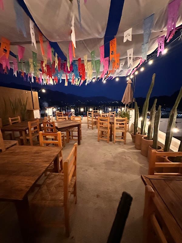 Fachada de Terraza Santa María con su terraza al aire libre y vista al atardecer — captura del exterior y mesas bajo luces