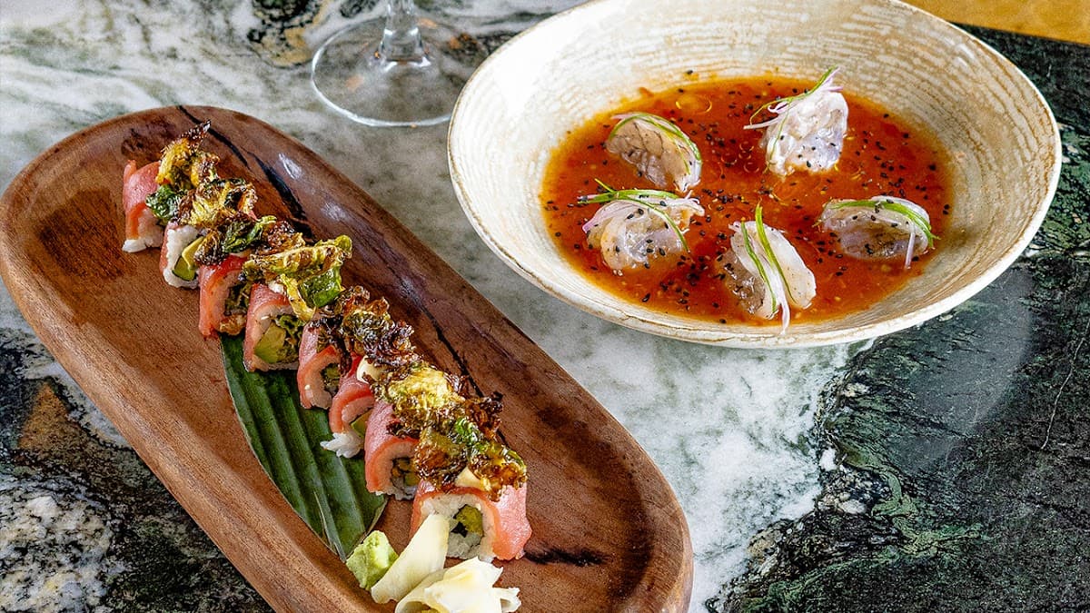 Tartar de atún en ANIMAL Tijuana — primer plano del plato sobre una tabla de madera, con fondo de barra iluminada