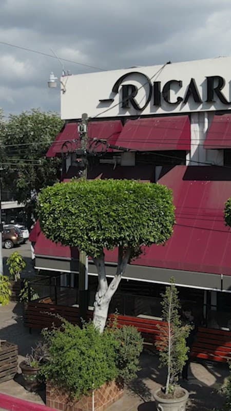 Mochomos Tijuana — vista del interior con barra iluminada y el plato de rib eye a la parrilla, mostrando la jugosidad del corte