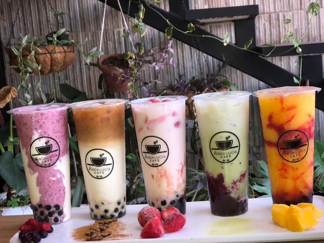 Fachada de Andalucía Café en Blvd. Cucapah, con plantas colgantes y clientes entrando por la mañana