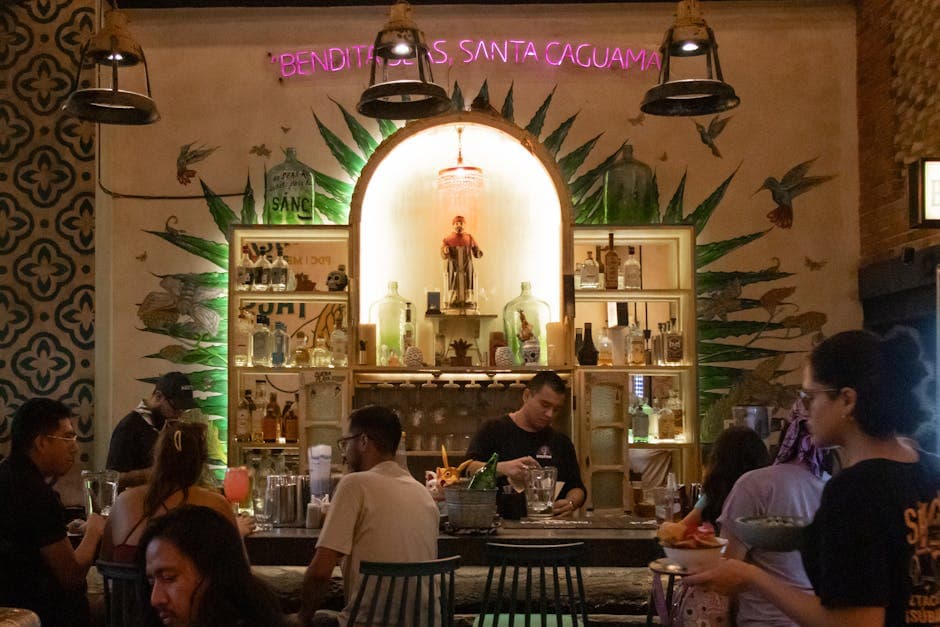 Lively Mexican bar scene with patrons enjoying drinks in a traditional setting.