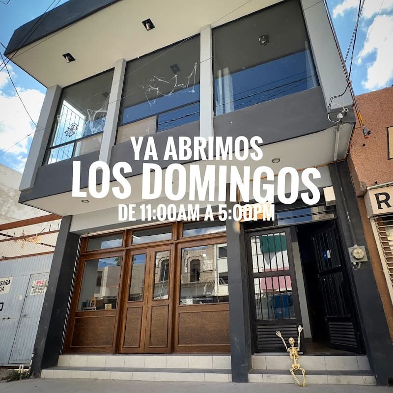 Fachada de Sinfonía - Café & Cultura con su letrero vintage y mesas al aire libre, mostrando la esquina de Av. Matamoros
