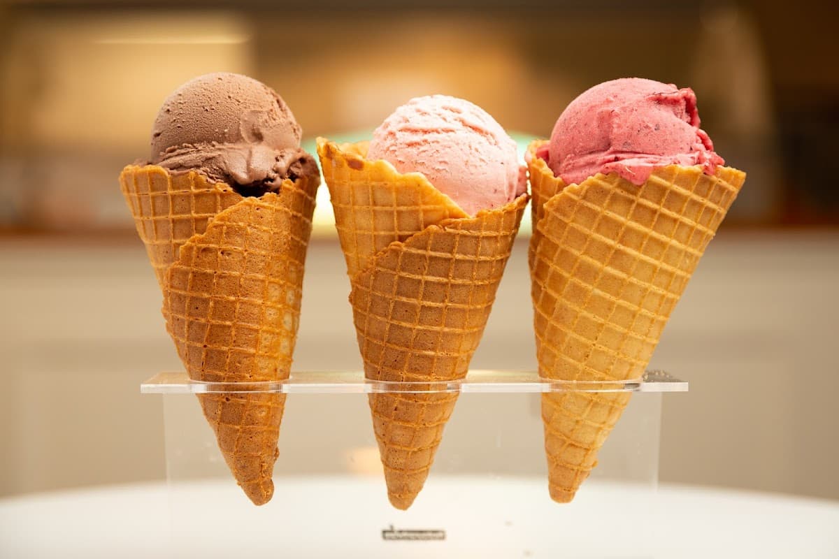 Helados Amoripás Allende mostrando su helado de mora vegano en un cono, con la fachada de Ignacio Allende 7 y clientes disfrutando