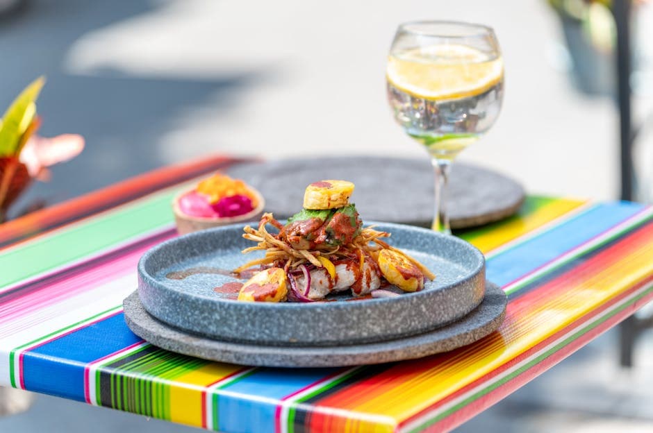 Colorful Mexican gourmet dish served outdoors in CDMX with a refreshing cocktail.