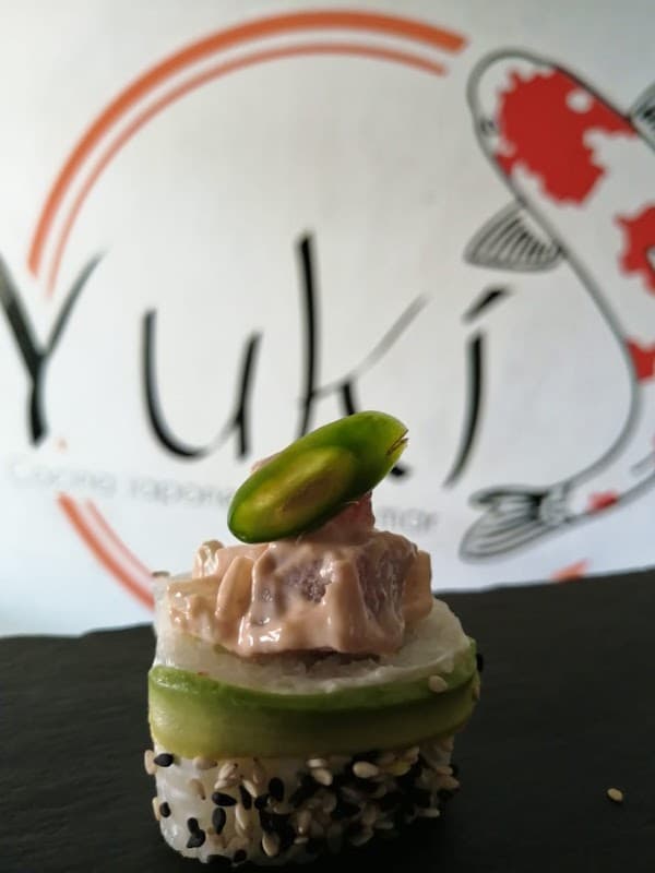 Exterior de Yukí con su letrero de farol y un primer plano de un California roll sobre la barra