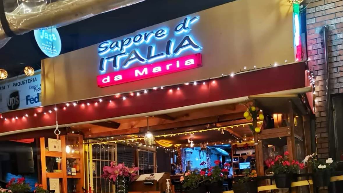 Fachada de Sapore d Italia en Avenida Colonia del Valle, con su letrero iluminado y mesas en la acera — captura la atmósfera nocturna