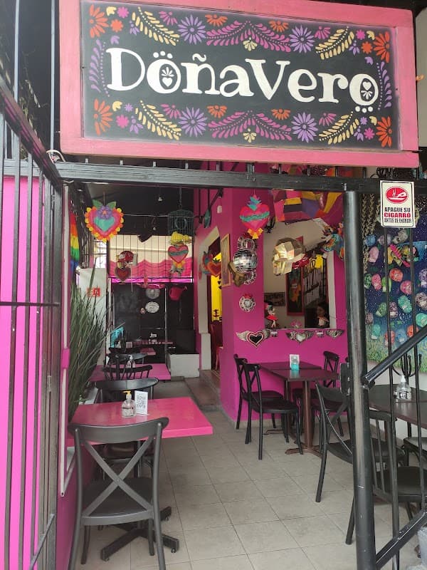 Fachada colorida de Doña Vero en Eje Vial 2 poniente, con su letrero de neón y la fila de clientes esperando
