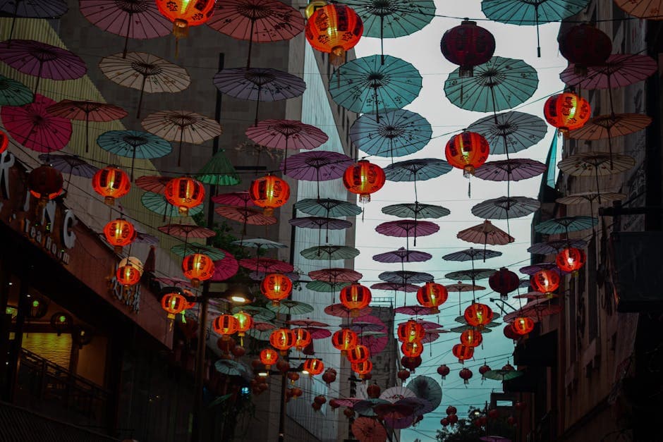 Colorful lanterns and umbrellas create a festive atmosphere in Mexico City's bustling street.