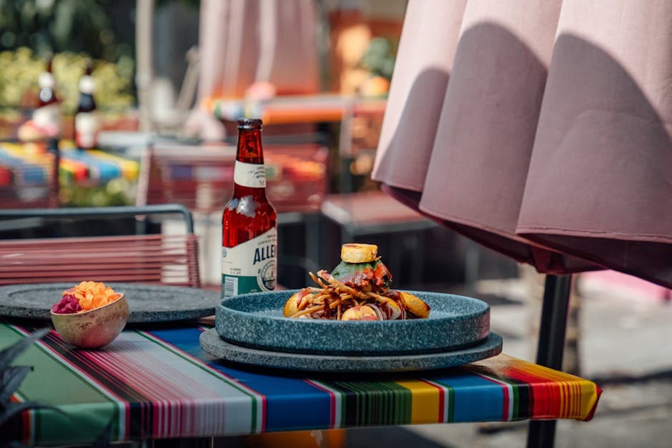 Vibrant outdoor dining scene featuring a beer bottle and artful dish in Mexico City.