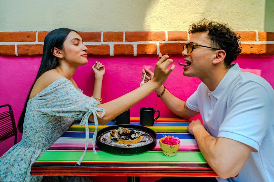 A joyful couple shares a dessert at a colorful café in Mexico City, CDMX.