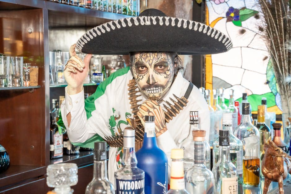 Man in Catrina costume behind a bar in Mexico City, celebrating Day of the Dead.