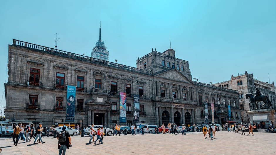View of the historic Palacio de Minería with Torre Latinoamericana in the backdrop, bustling with people.