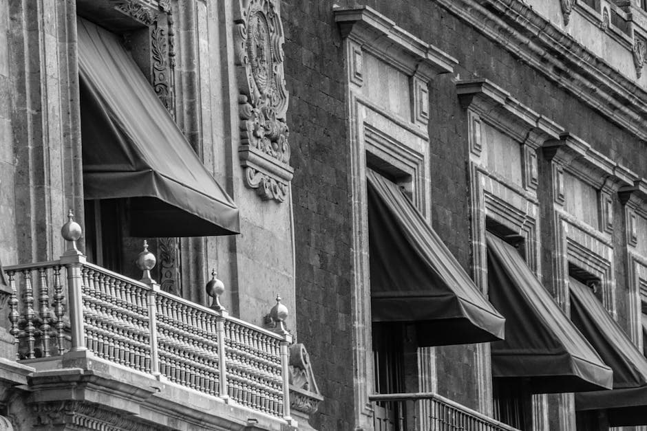 Black and white image of ornate historic balconies in Ciudad de México, showcasing vintage architecture.