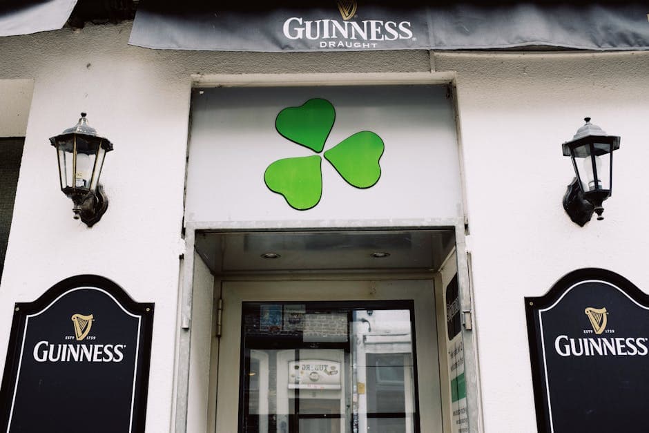 Exterior of an Irish pub with shamrock and Guinness signage, inviting visitors.