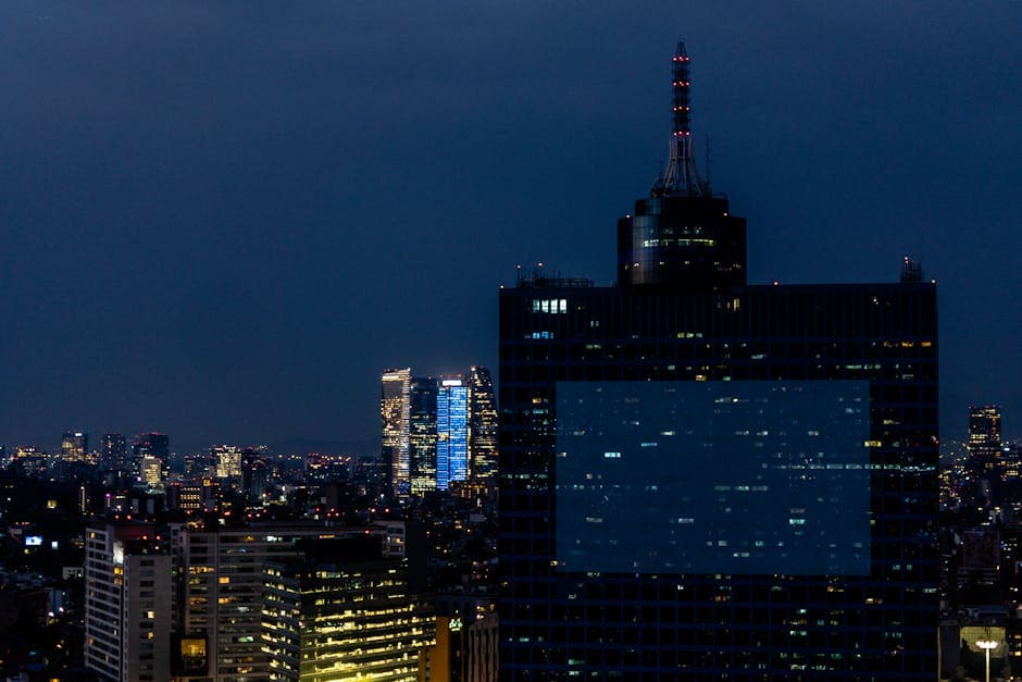 Evening cityscape of Ciudad de México with illuminated skyscrapers under a twilight sky.