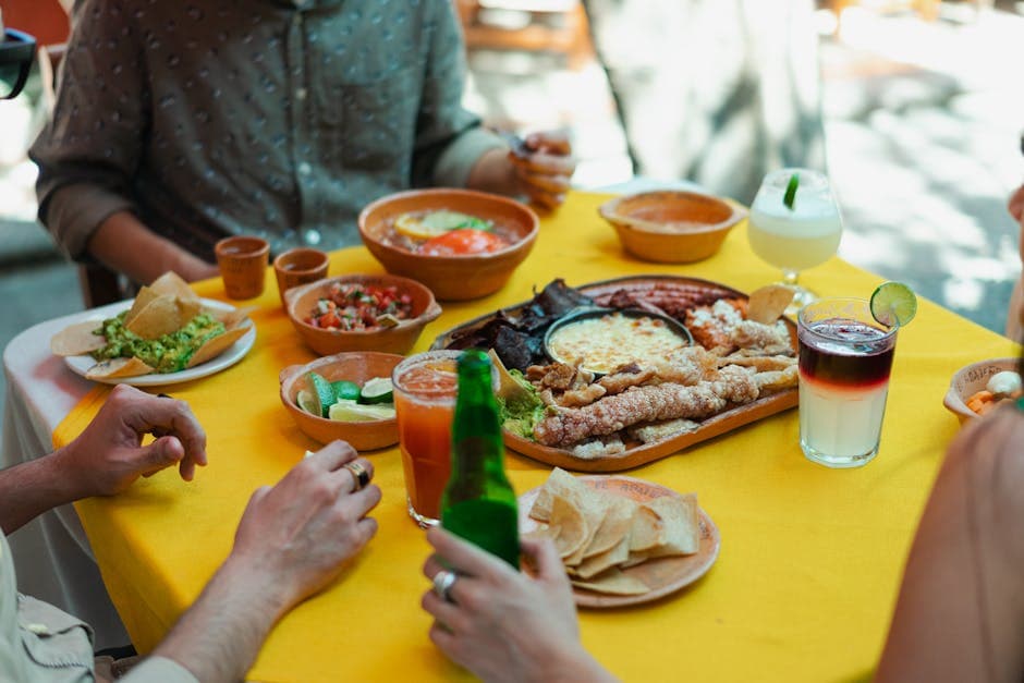 Vibrant scene of Mexican food, drinks, and people enjoying meals outdoors.