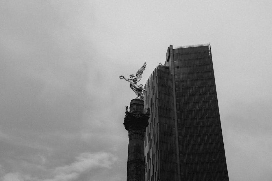 Black and white view of Angel of Independence with skyscraper in Mexico City.