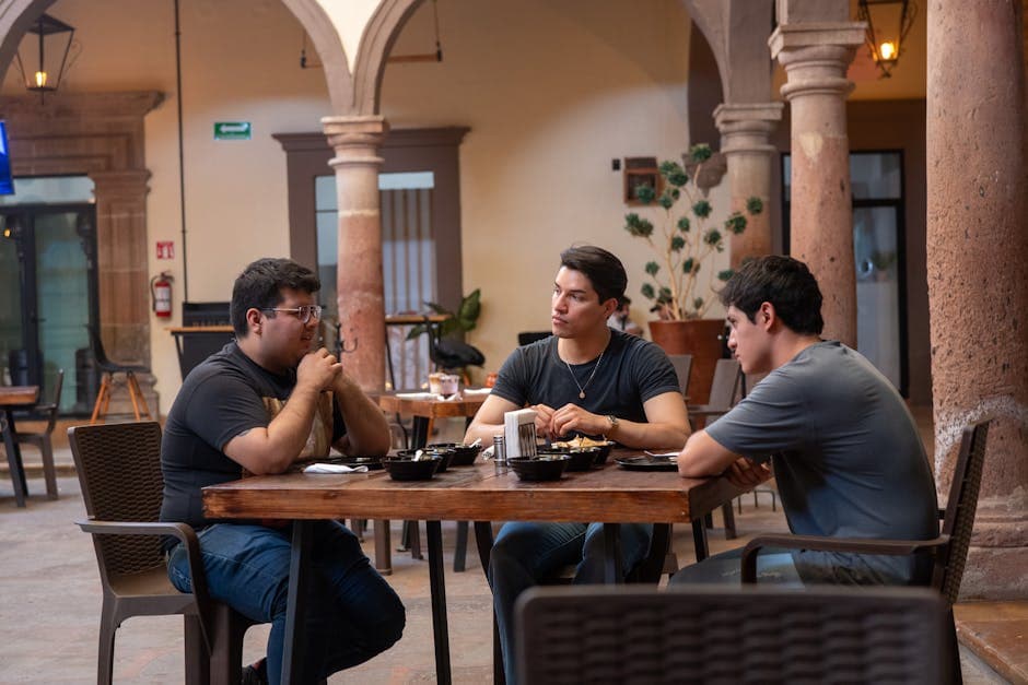 Three men enjoying Mexican food at an indoor courtyard restaurant in Guanajuato, Mexico.