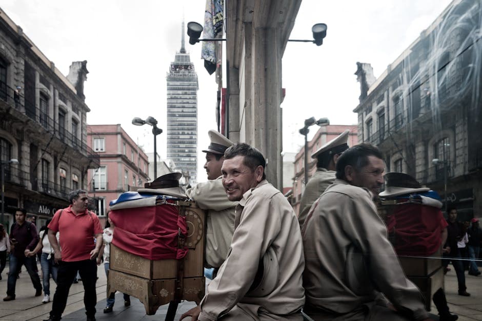 Urban street scene in Mexico City featuring a man beside a mirrored building.