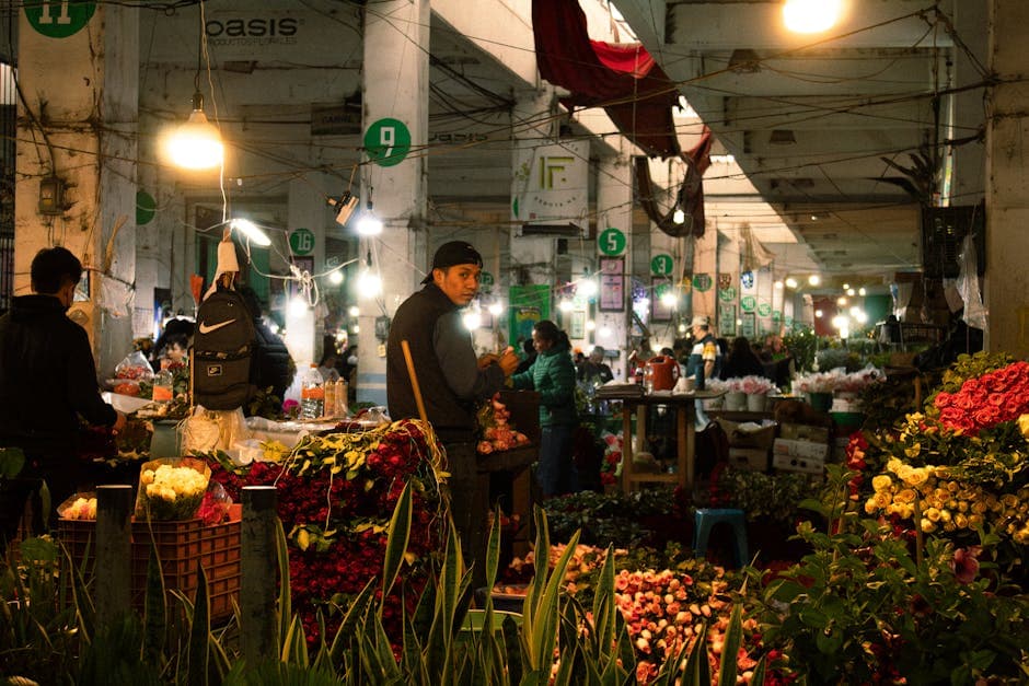 A vibrant indoor flower market in Mexico City bustling with activity and colorful blooms.
