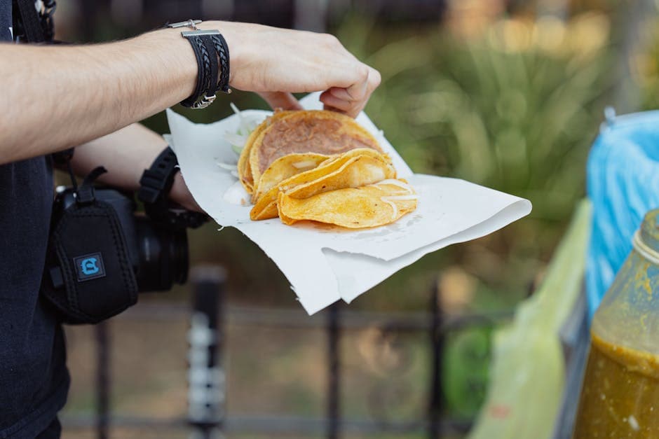 Close-up of a person holding tacos from a street vendor in Mexico City.
