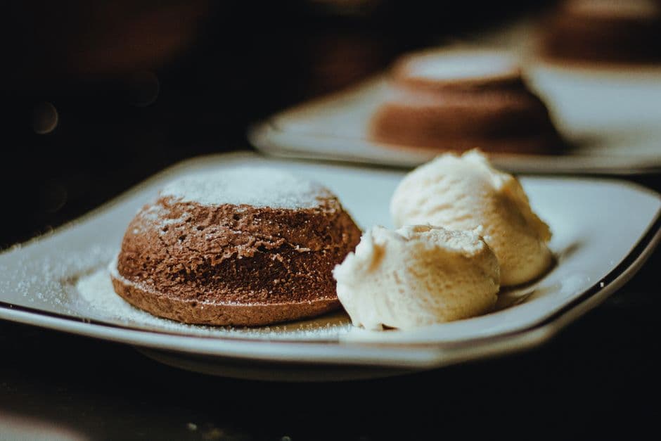 Indulge in a rich brownie served with scoops of creamy vanilla ice cream on a stylish plate.