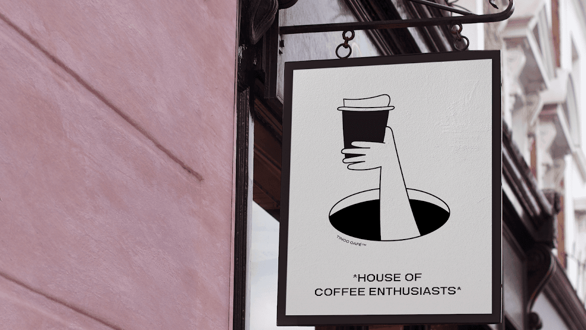 Exterior de Tinoc Café con su fachada verde y mesas en la terraza, mostrando una taza de café latte sobre la mesa