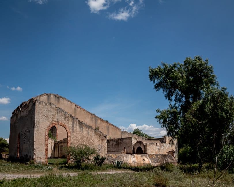 Abandoned building ruins in Mineral de Pozos, Mexico, under a clear blue sky.