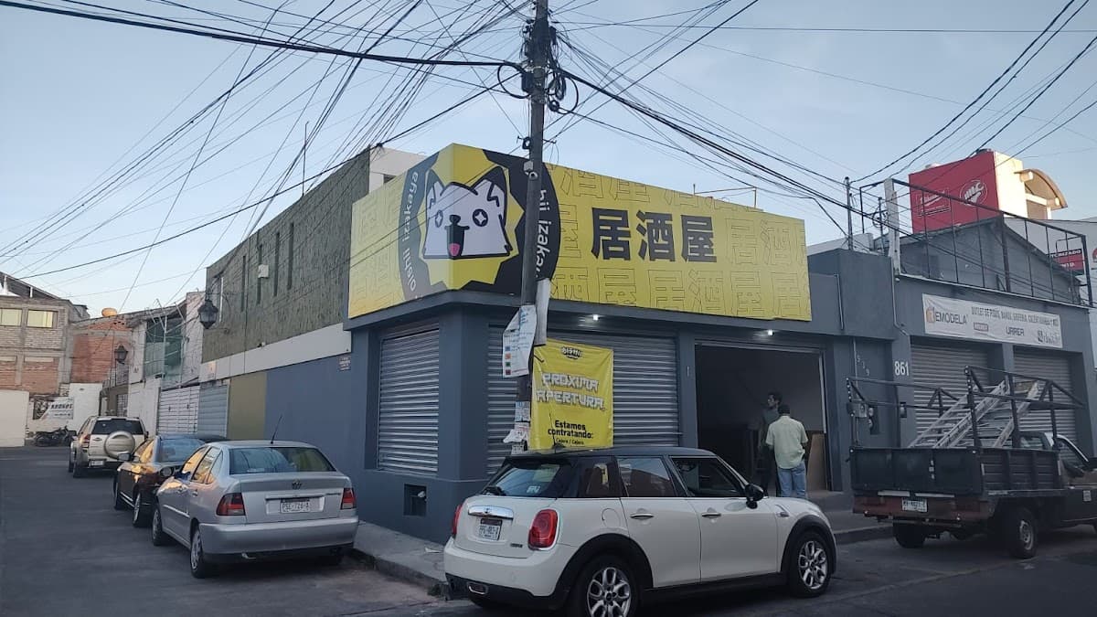 Exterior de Magari Cafetería Japonesa con su letrero rojo y una mesa con ramen humeante