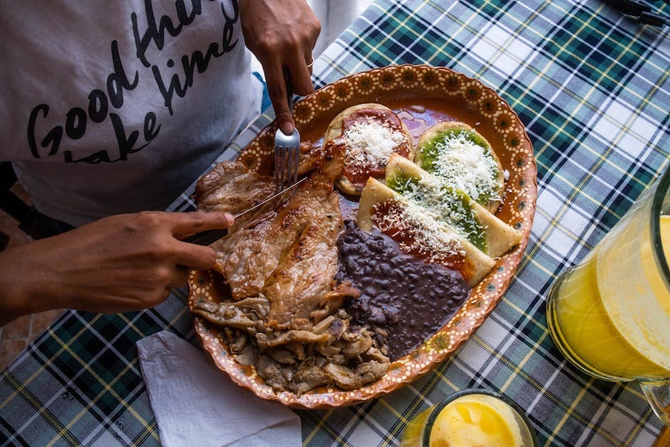 Delicious traditional Mexican dish with meats and colorful sauces served on a decorative plate.