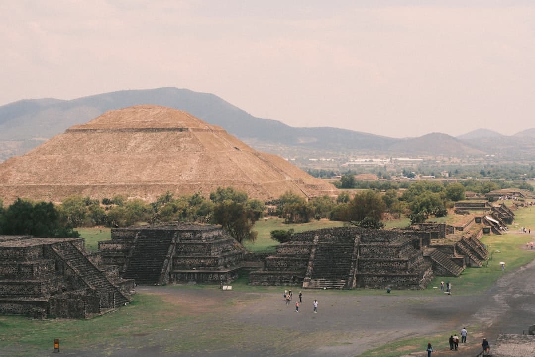 Ancient pyramids and structures with mountains in the background.