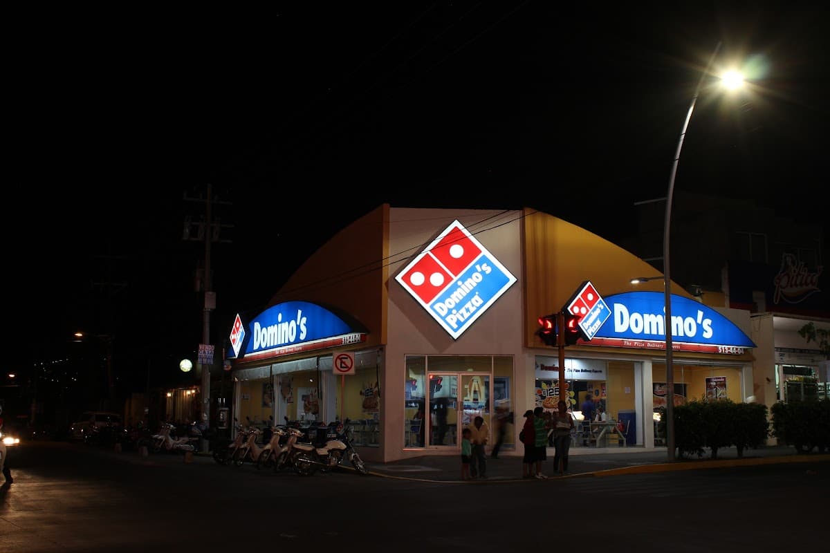 Fachada de Domino's Pizza Reforma con su letrero rojo y clientes en la zona de autoservicio