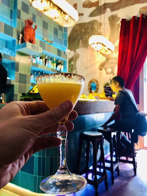 Bar El Espacio en Reforma 502a, con su barra iluminada y botellas de mezcal al fondo — vista interior nocturna