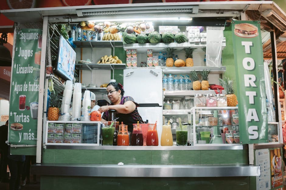 Colorful juice stand with fresh fruits and beverages in Oaxaca market.