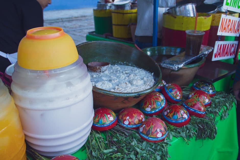 Vibrant Mexican food stall featuring traditional drinks and jicara bowls, offering a cultural experience.