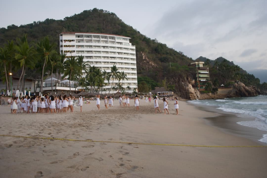 a group of people standing on top of a sandy beach