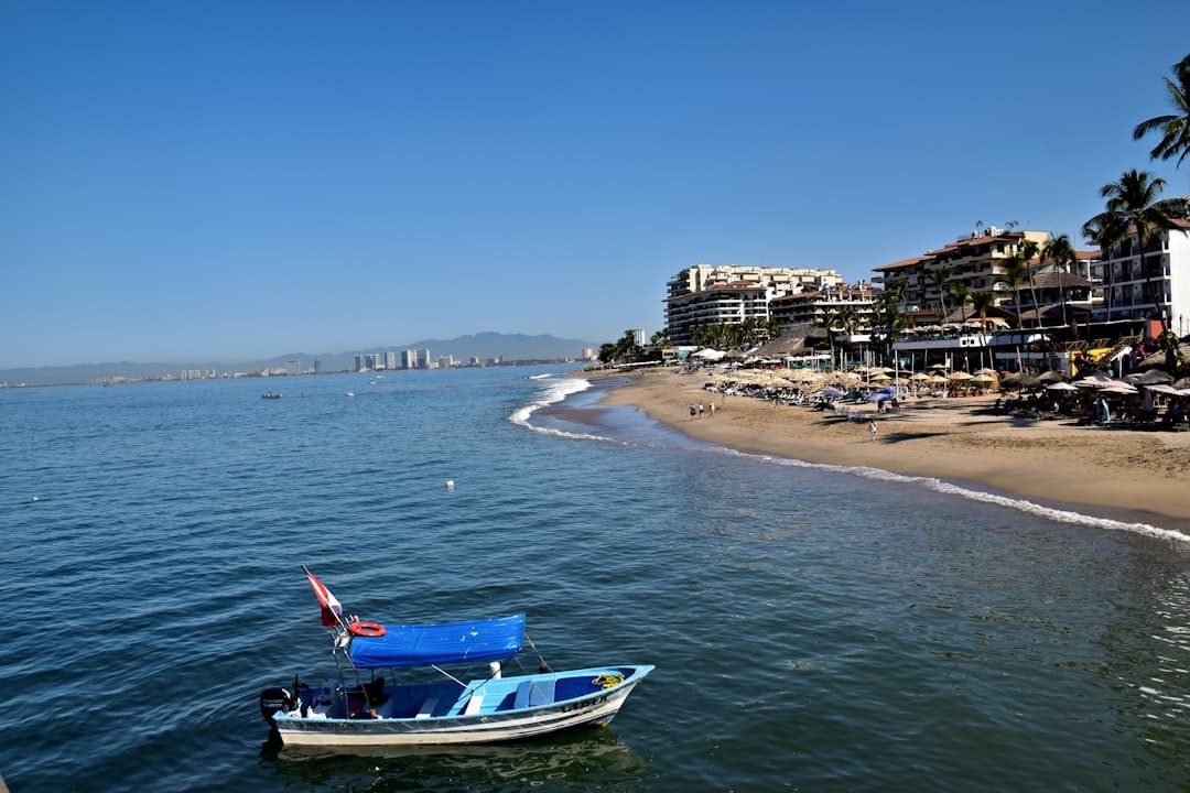 Beach scene with boats and resort buildings.